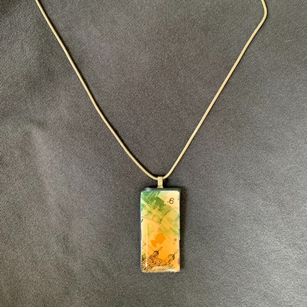 Silver necklace with rectangle pendant depicting scenes of England